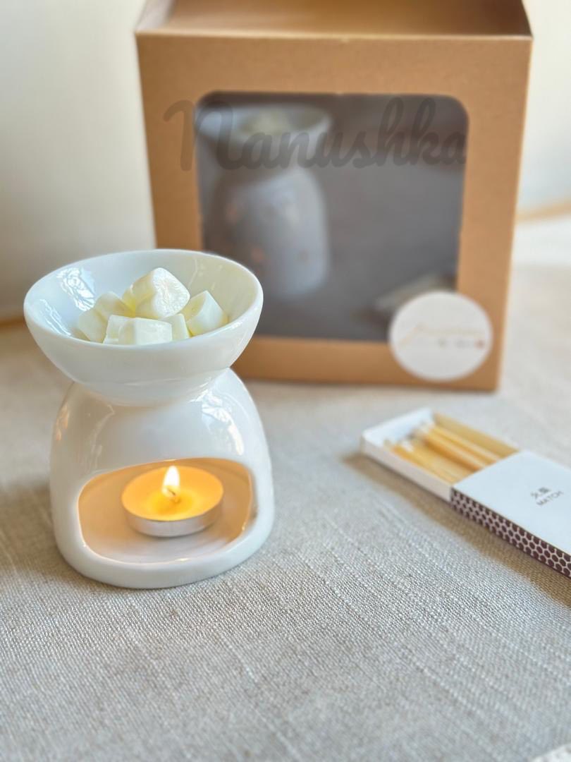 Wax warmer with a lit candle and cented wax hearts